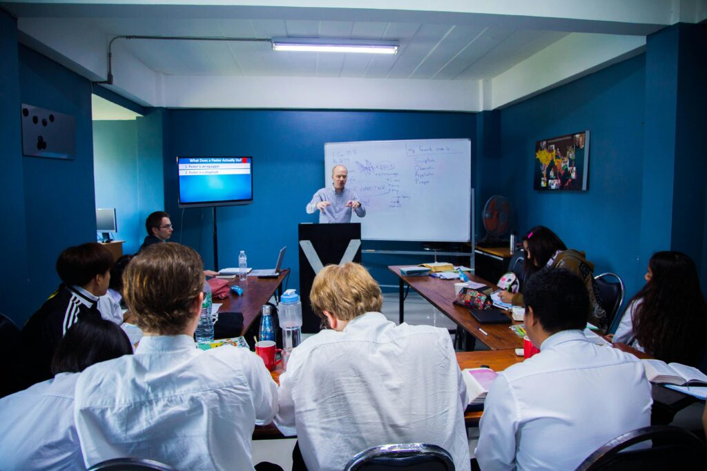 A professional leadership workshop with participants collaborating around a conference table.