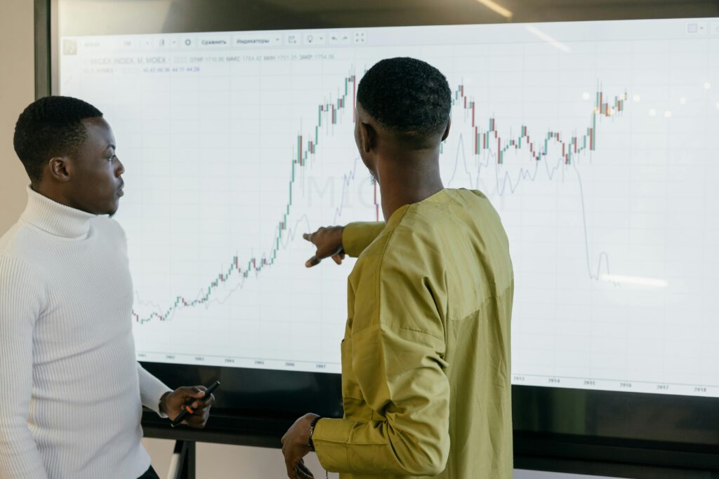 A professional sales team reviewing metrics on a screen during a strategy meeting.